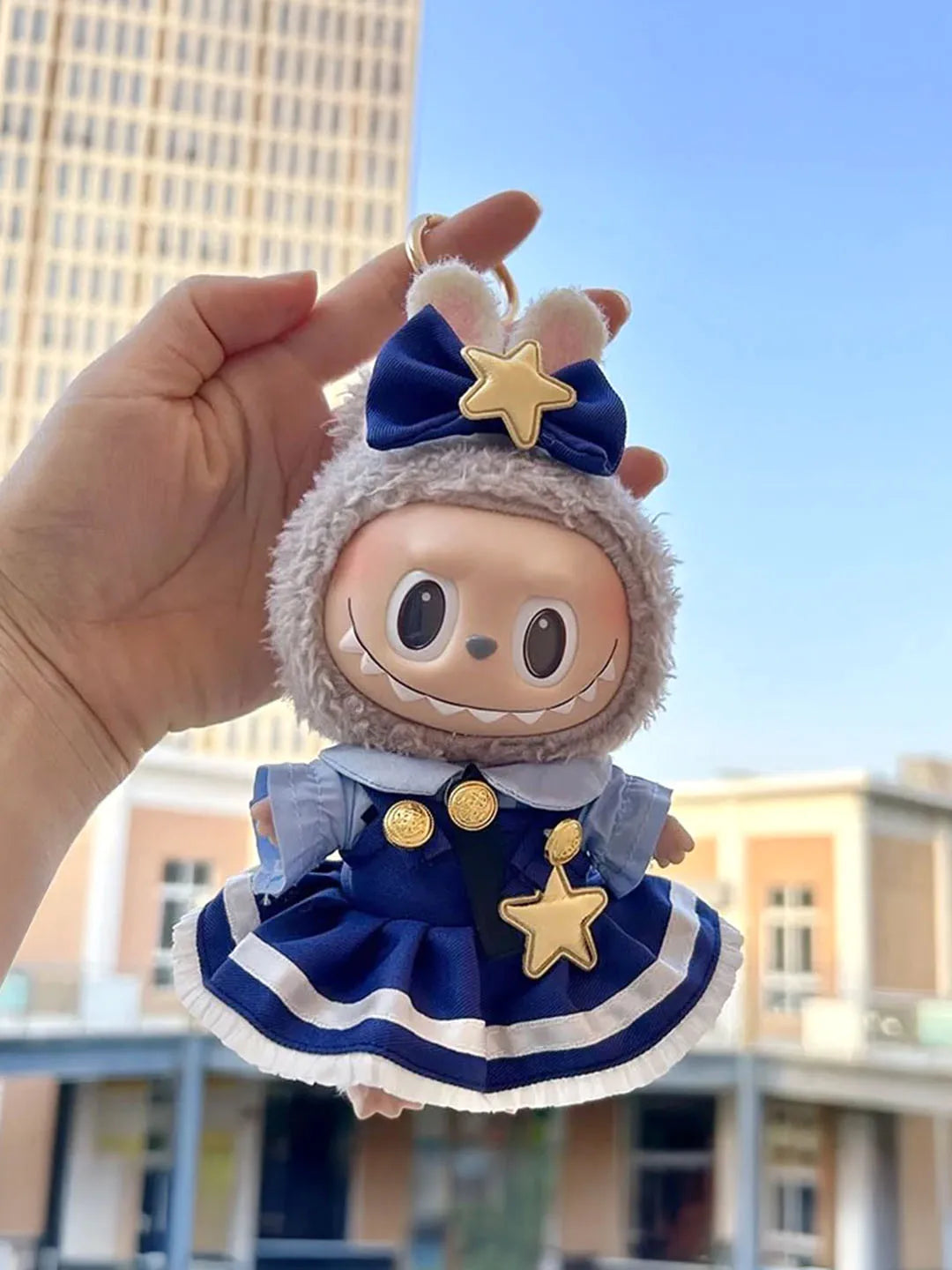 Starry Officer Dress on 17cm plush doll: navy blue officer-style dress with gold button details, white-striped skirt hem.
