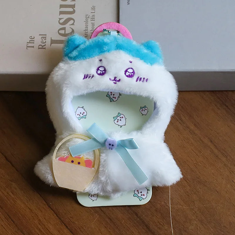 Bear Cape Outfit on 17cm plush doll: white plush bear-face hooded cape, blue ribbon bow with charm detail.