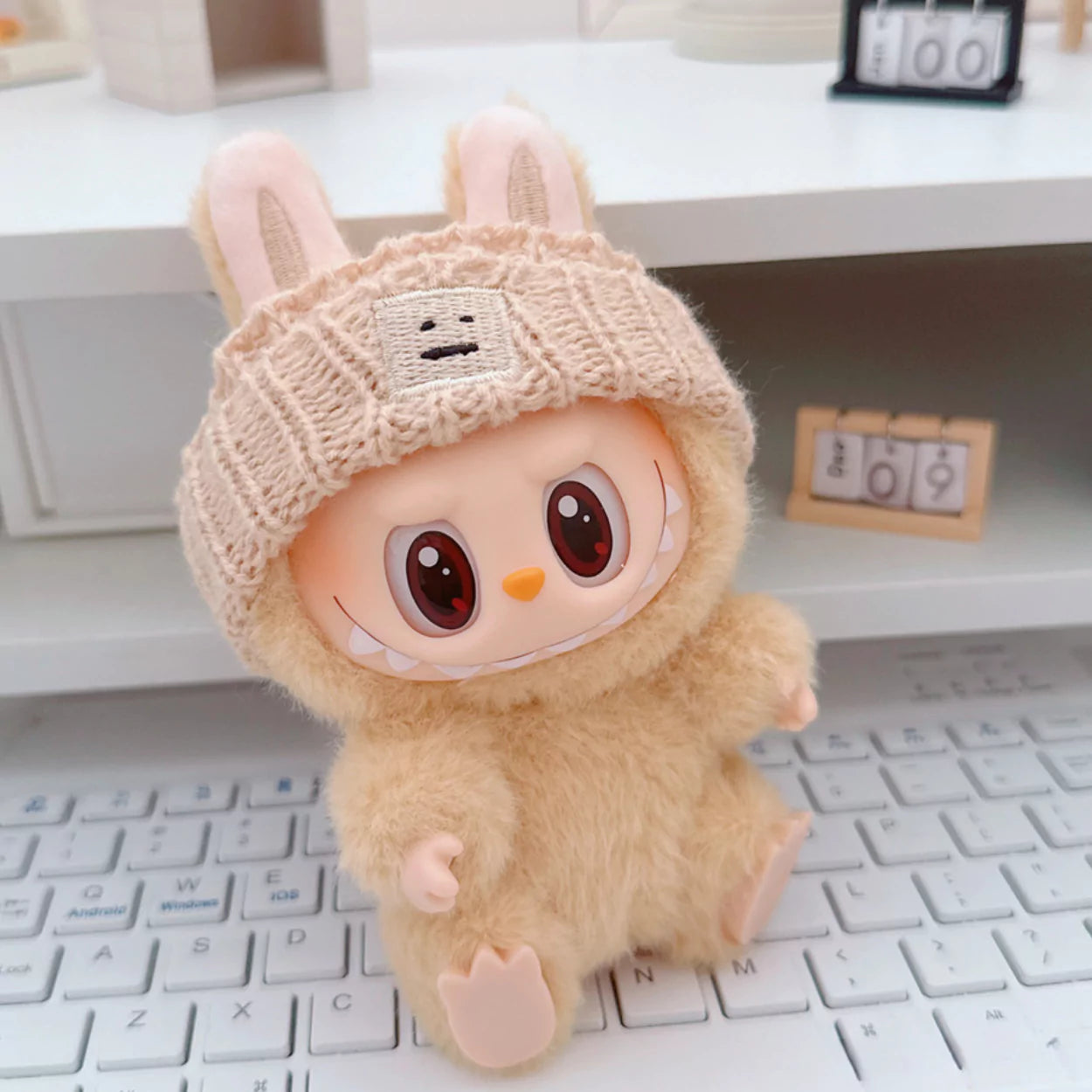 Beige Knit Beanie on 17cm plush doll: beige ribbed knit beanie hat, embroidered smiley face patch detail.