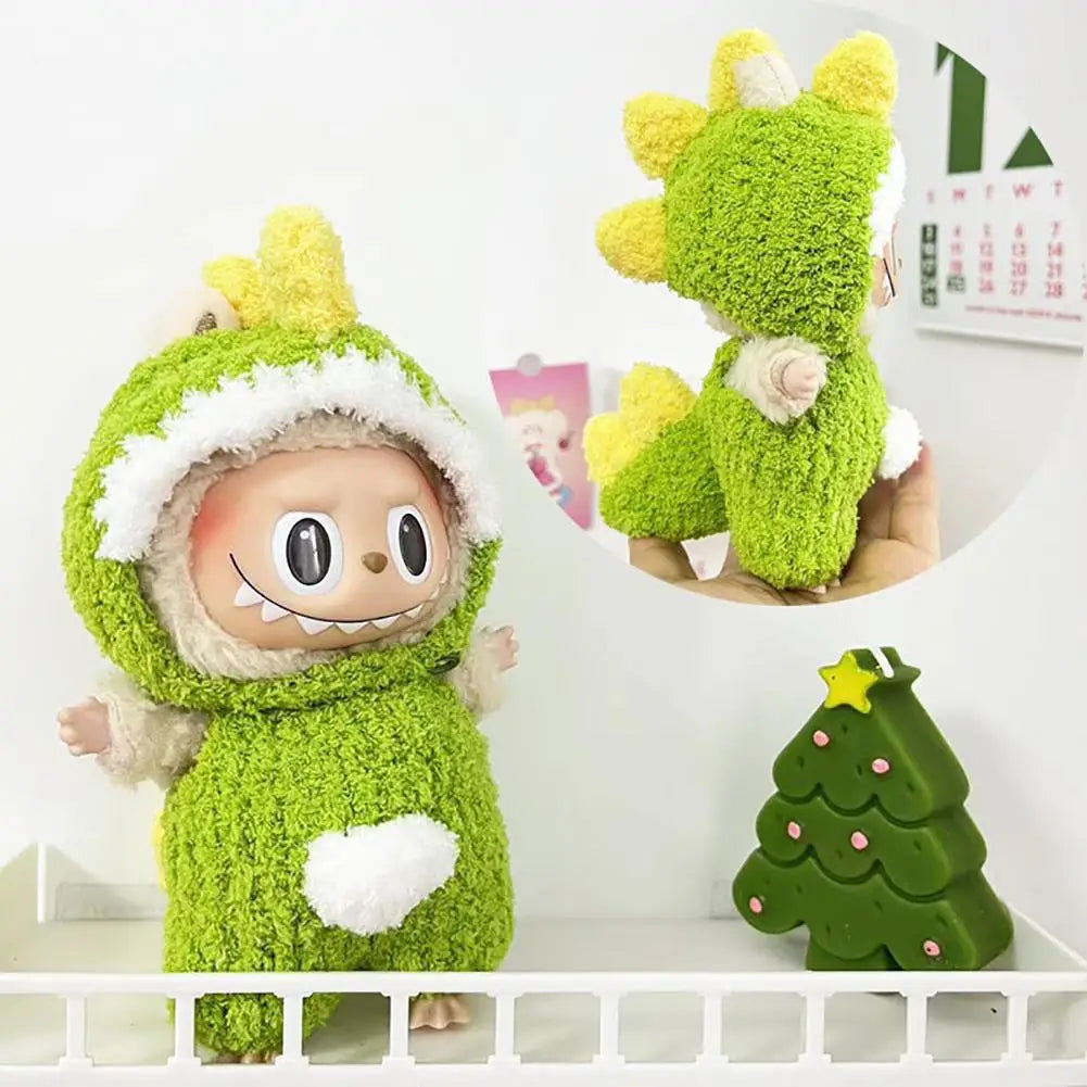Dino Hooded Accessory on 17cm plush doll: green fuzzy full-body dinosaur onesie, attached hood with yellow spiky dino plates.