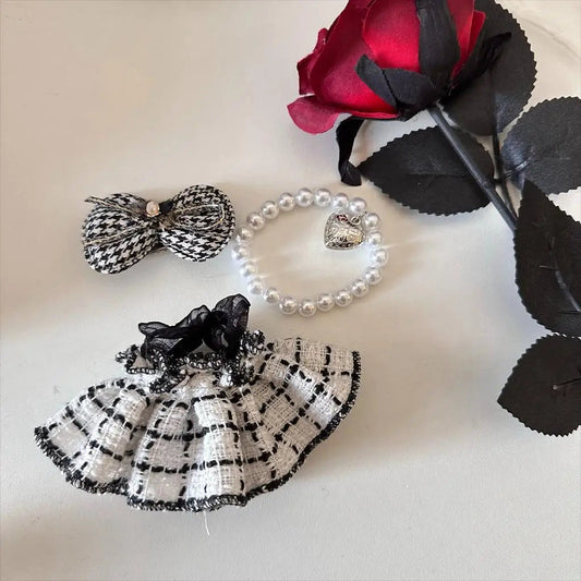 Elegant Coco Tweed Dress on 17cm plush doll: black-and-cream houndstooth tweed skirt with black organza bow, matching houn...